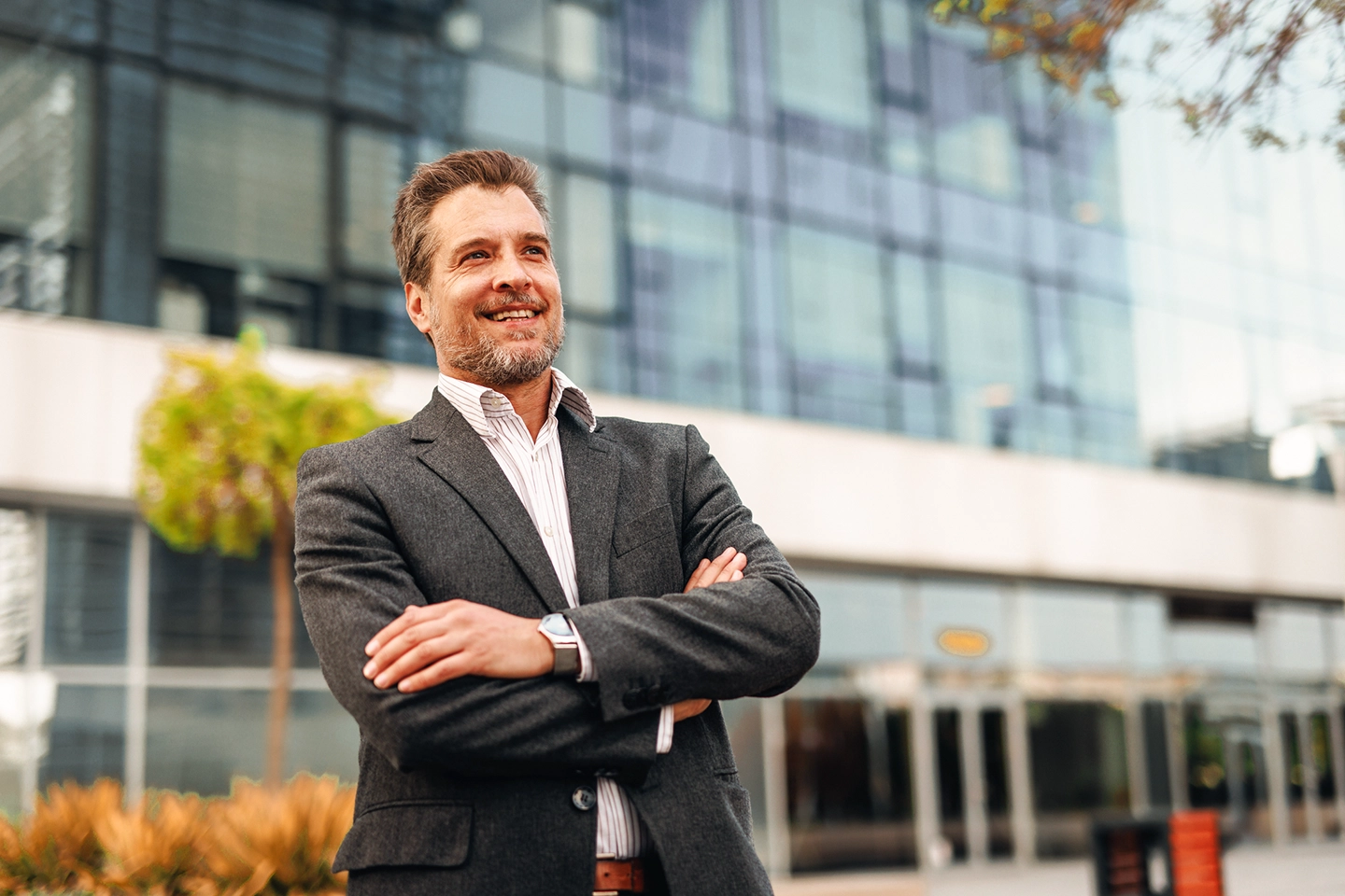 Business man smiling in front of commercial building